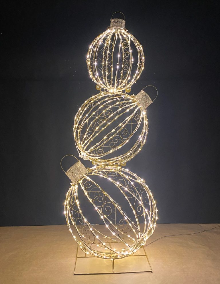 Drei leuchtende, filigrane Drahtweihnachtskugeln übereinander angeordnet.