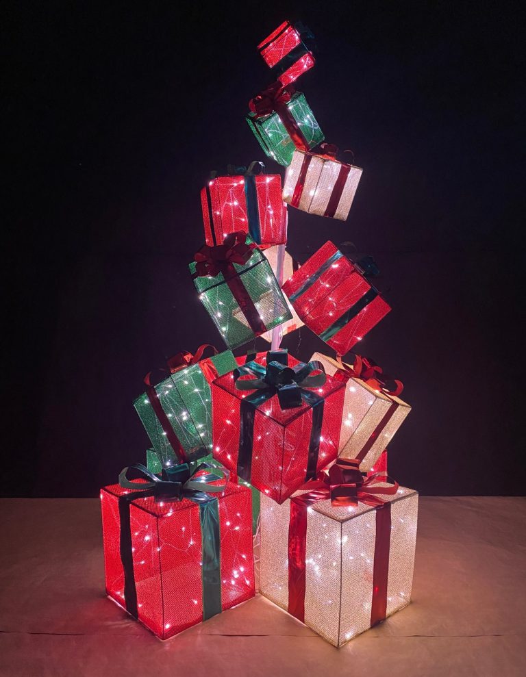 Leuchtende, dekorierte Geschenke in rot, grün und weiß, übereinander gestapelt in Form eines Tannenbaumes.